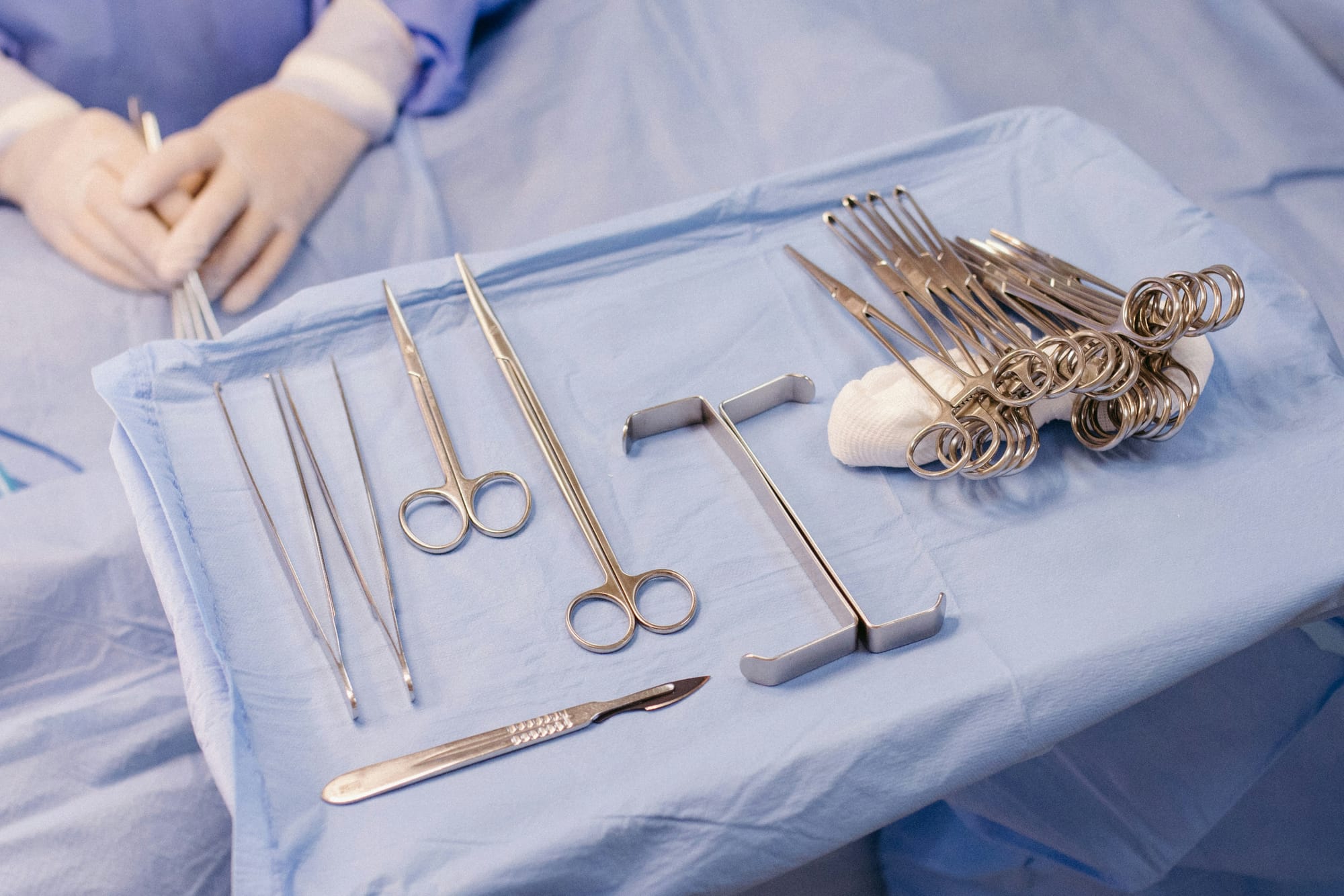 A hospital bed with surgical equipment on top of it.